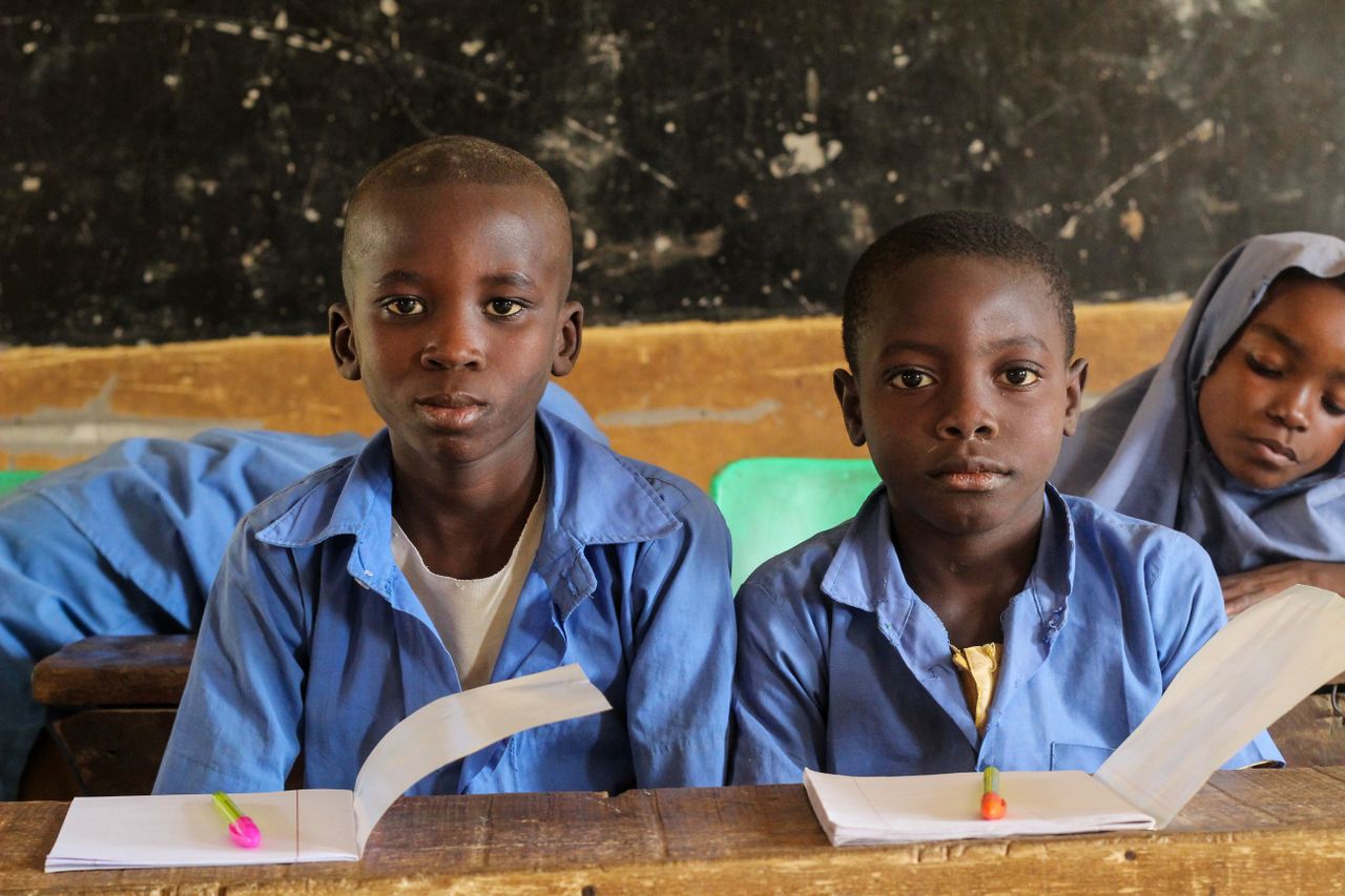 Children in a rural classroom setting focused on their studies, showcasing educational diversity.